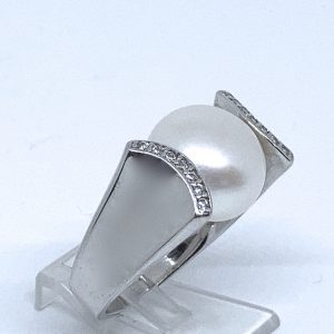 Sortija con aro en forma de"U" ,adornada con circonitas y, rematada con Gran perla cultivada en el centro.