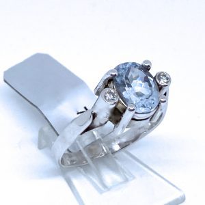 Sortija con Aguamarina en talla oval, y dos brillantes en chatonne.