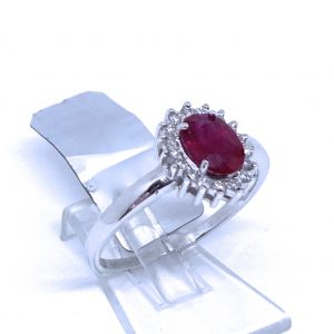 Sortija Rubí Birmania en talla oval orlado de brillantes.