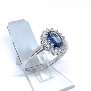 Sortija zafiro Birmania en talla oval orlado de brillantes.