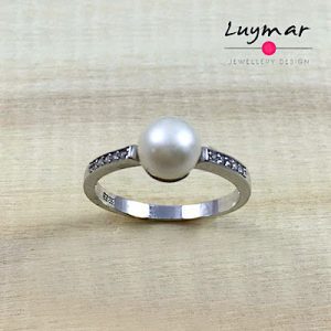 Sortija con fino aro cuajado de circonitas , en Plata de Ley ,rematada con perla cultivada .